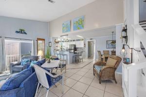 sala de estar y cocina con sofá azul y sillas en Unplugged, en Gulf Shores