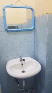 uma casa de banho com um lavatório branco e um espelho. em Guest House GRIYA THAMRIN SYARIAH em Bonorejo