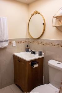 ein Bad mit einem Waschbecken und einem Spiegel in der Unterkunft The Green Door Bungalow in Naples