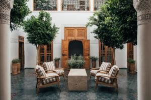 a courtyard with chairs and a table in a building at Riad no37 in Marrakesh