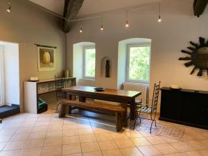 - une salle à manger avec une table et des chaises en bois dans l'établissement Batîsse le Moulinage du Luol avec parc arboré, à Saint-Privat