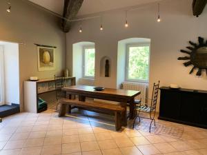 a dining room with a wooden table and chairs at Batîsse le Moulinage du Luol avec parc arboré in Saint-Privat