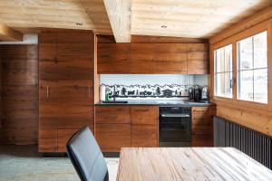 格林德瓦的住宿－Chalet Swiss Alps，厨房设有木墙和桌椅