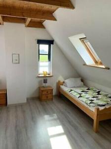 a attic room with a bed and a window at Ferienhaus für 7 Pers./Schlei in Oersberg