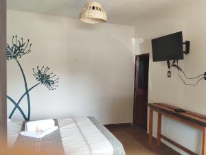 Un dormitorio con una cama y un televisor en la pared. en Calli Sofi Posada, en Tepoztlán 23 fotos más