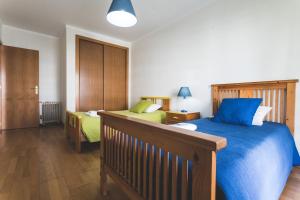 佩尼謝的住宿－Best Houses 35 - Baleal Sol，一间卧室配有一张带蓝色棉被的床