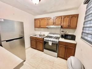 a kitchen with wooden cabinets and a stainless steel refrigerator at Acogedor departamento 3 recamaras in Reynosa