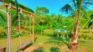 einen Park mit einer Schaukel und einer Palme in der Unterkunft Magic Green Dentro del Parque Tayrona in El Zaino