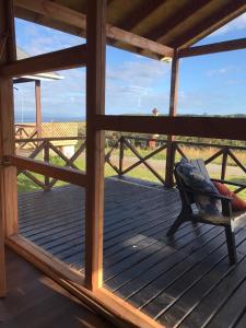a bench on a deck with a view of a field at Cabañas Nuestro Sueño in Aucho