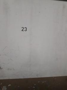 Una pared blanca con el número. en La Perla 23 cochera con control remoto en Mar del Plata