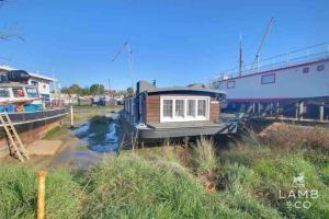 a small house on a boat in the water at Toosey Lass - St Osyth creek in Saint Osyth