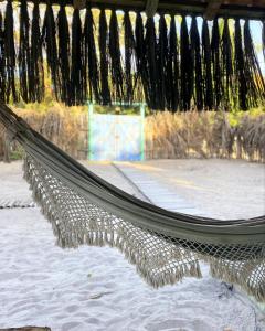 eine Hängematte am Strand mit Tennisplatz in der Unterkunft Quintal do Céu Caraíva in Porto Seguro