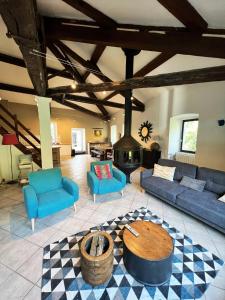 uma grande sala de estar com sofás azuis e uma lareira em Batîsse le Moulinage du Luol avec parc arboré em Saint-Privat