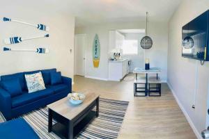 sala de estar con sofá azul y mesa en Luxury House with delightful beach Style!, en Dania Beach