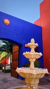 una fuente frente a un edificio azul en Hotel Chuburna, en Chuburná