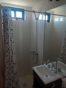 y baño con cortina de ducha y lavamanos. en Miracielos en San Rafael