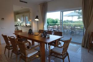 uma cozinha e sala de jantar com uma mesa de madeira e cadeiras em Villa Formosa Golf na Quinta do Lago