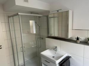 een badkamer met een glazen douche en een wastafel bij Casa Ideal in Bruchsal