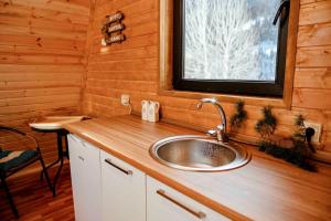 a kitchen with a sink in a log cabin at Cozy chalet in Mestia in Mestia