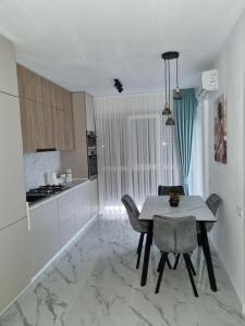 una cucina e una sala da pranzo con tavolo e sedie di Roxana Residence a Oradea