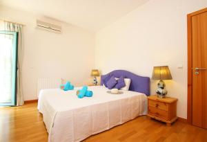 Un dormitorio con una cama con almohadas azules. en Apartment Mykonos by Algarve Vacation, en Albufeira