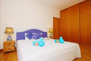 Un dormitorio con una gran cama blanca con almohadas azules. en Apartment Mykonos by Algarve Vacation, en Albufeira 42 fotos más