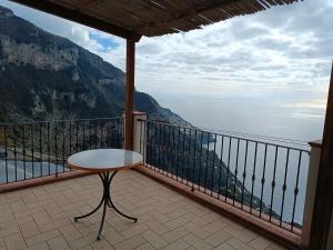 balcone con tavolo e vista sull'oceano di NINO'S IN NOCELLE a Positano