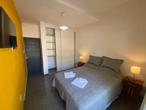 Un dormitorio con una cama con dos pañuelos. en departamento godoy cruz en Godoy Cruz