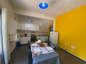 Habitación con mesa y cocina con paredes amarillas. en departamento godoy cruz en Godoy Cruz
