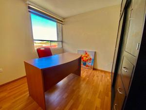 un ufficio con scrivania e finestra e una scrivania di Hermoso departamento en Cuautlancingo a Santa María Coronanco