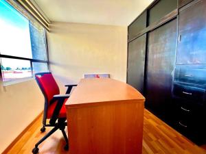 un ufficio con scrivania e sedia rossa di Hermoso departamento en Cuautlancingo a Santa María Coronanco