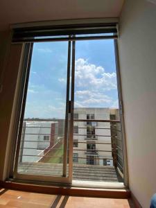a large window with a view of a building at Hermoso departamento en Cuautlancingo in Santa María Coronanco