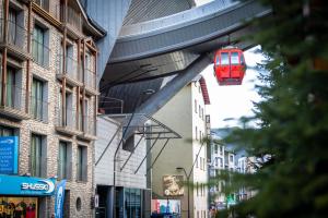 eine rote Seilbahn, die über einer Stadtstraße hängt in der Unterkunft Apartments TELECABINE 365 in La Massana