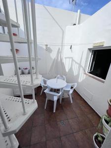 a balcony with a table and chairs and a tv at La casita de Yolanda in Caleta de Sebo
