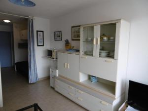 kuchnia z białą szafką z naczyniami w obiekcie Appartement 5 pers avec loggia, parking privé à Sète - FR-1-472-166 w mieście Sète