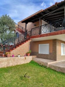 a brick house with stairs and a balcony at ALEX HOUSE in Nea Potidaea