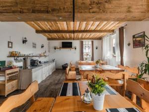 uma grande sala com mesas e cadeiras e uma cozinha em Privat na Vŕšku em Ždiar