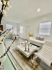un soggiorno con mobili bianchi e pavimento in vetro di Modern & New,Excellent Location Miami a Miami