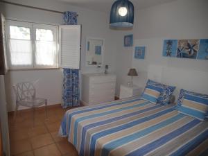 een slaapkamer met een bed, een stoel en een raam bij Real Village Praia Verde 142 in Praia Verde