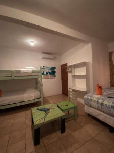 a room with two bunk beds and a table at Hotel Maya Jade in Monterrico