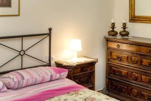 a bedroom with a bed and a dresser and a lamp at Appartamento Cosimo in Florence