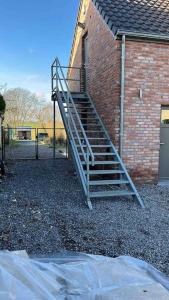 a metal staircase in front of a brick building at le Grand Vivier- 68 M2 in Héron