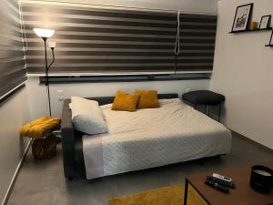 Un dormitorio con una cama con almohadas amarillas y una mesa. en le Grand Vivier- 68 M2, en Héron
