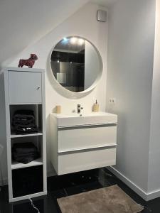 a white bathroom with a sink and a mirror at le Grand Vivier- 68 M2 in Héron