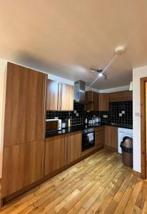 duża kuchnia z drewnianymi szafkami i drewnianą podłogą w obiekcie Cosy City Centre Apartment w mieście Inverness