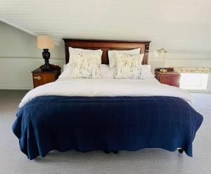 1 dormitorio con 1 cama grande con manta azul en Kasteelberg Place • Stay, en Riebeek-Kasteel