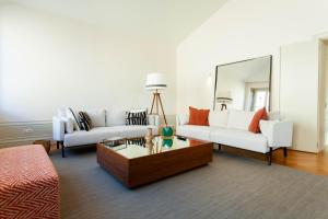 a living room with two white couches and a mirror at The Palace Penthouse in Porto