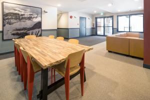 une salle de conférence avec une table et des chaises en bois dans l'établissement The Approach Hotel, à Panorama