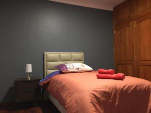 a bedroom with a bed with two red towels on it at Tu experiencia comienza aquí Departamento 3D 3C Achumani a pasos de la calle 29 in La Paz