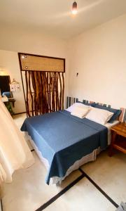 een slaapkamer met een blauw bed in een kamer bij Morada IKIGAI KiteHouse in Prea